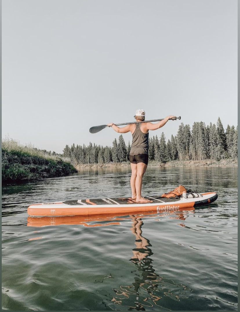 Andria on paddleboard on Alberta river in nature