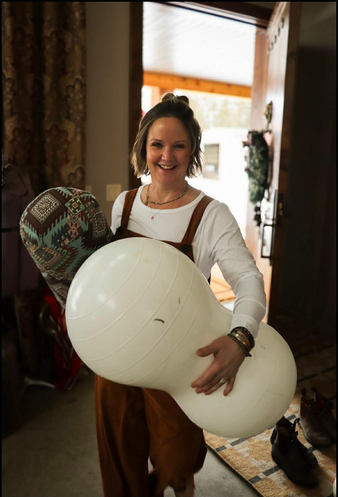 Andria smiling with a peanut ball, ready to support you through labour